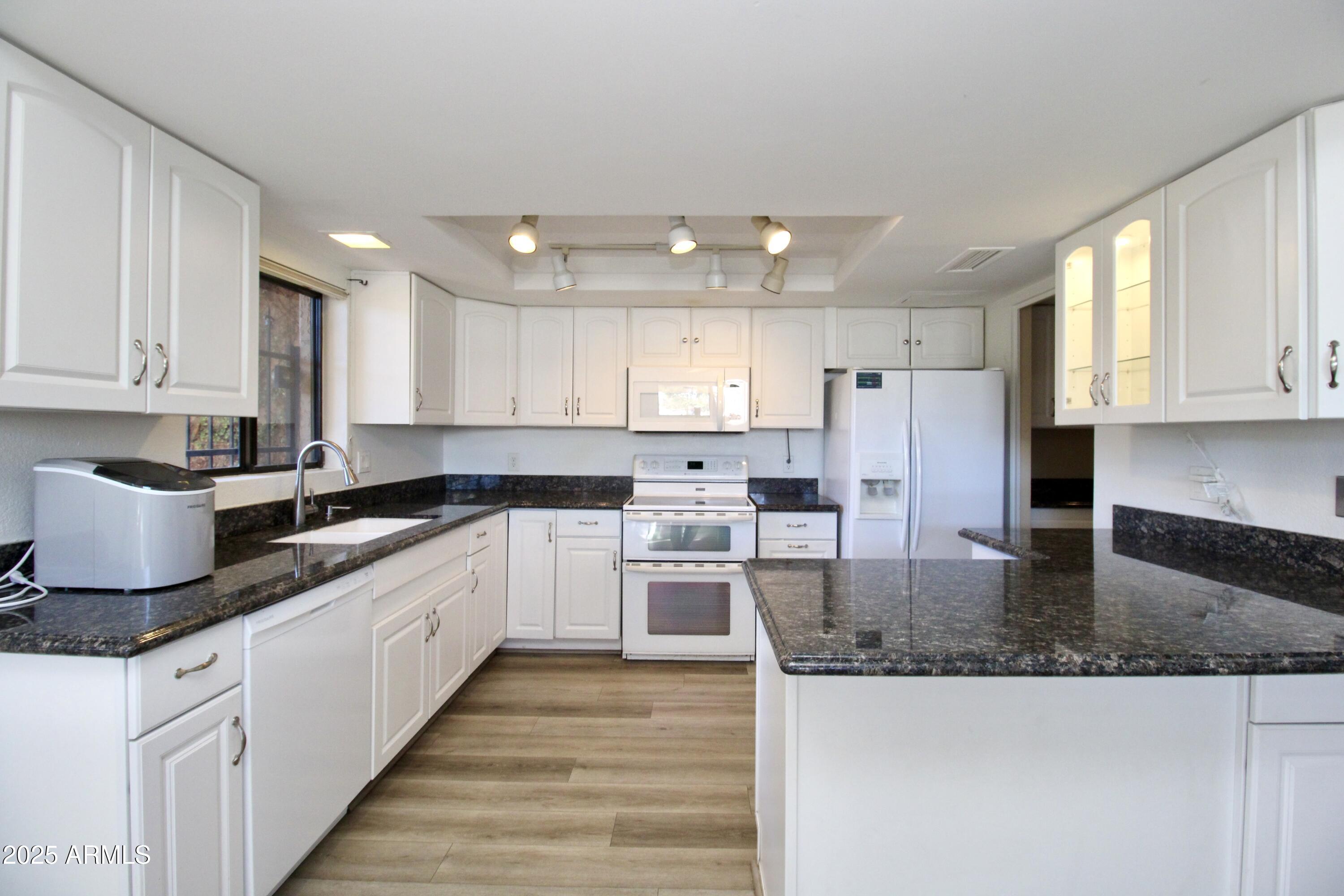 5330 North Central Avenue, Unit 19 Phoenix, AZ 85012 - Photo 2 of 33 a white kitchen with granite countertop stainless steel appliances and white cabinets