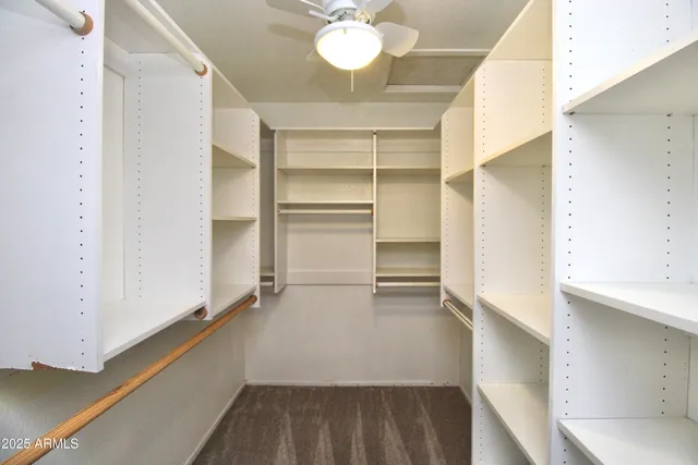 a view of walk in closet with empty racks