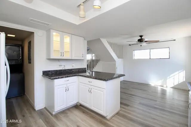 a kitchen with granite countertop a sink cabinets and wooden floor
