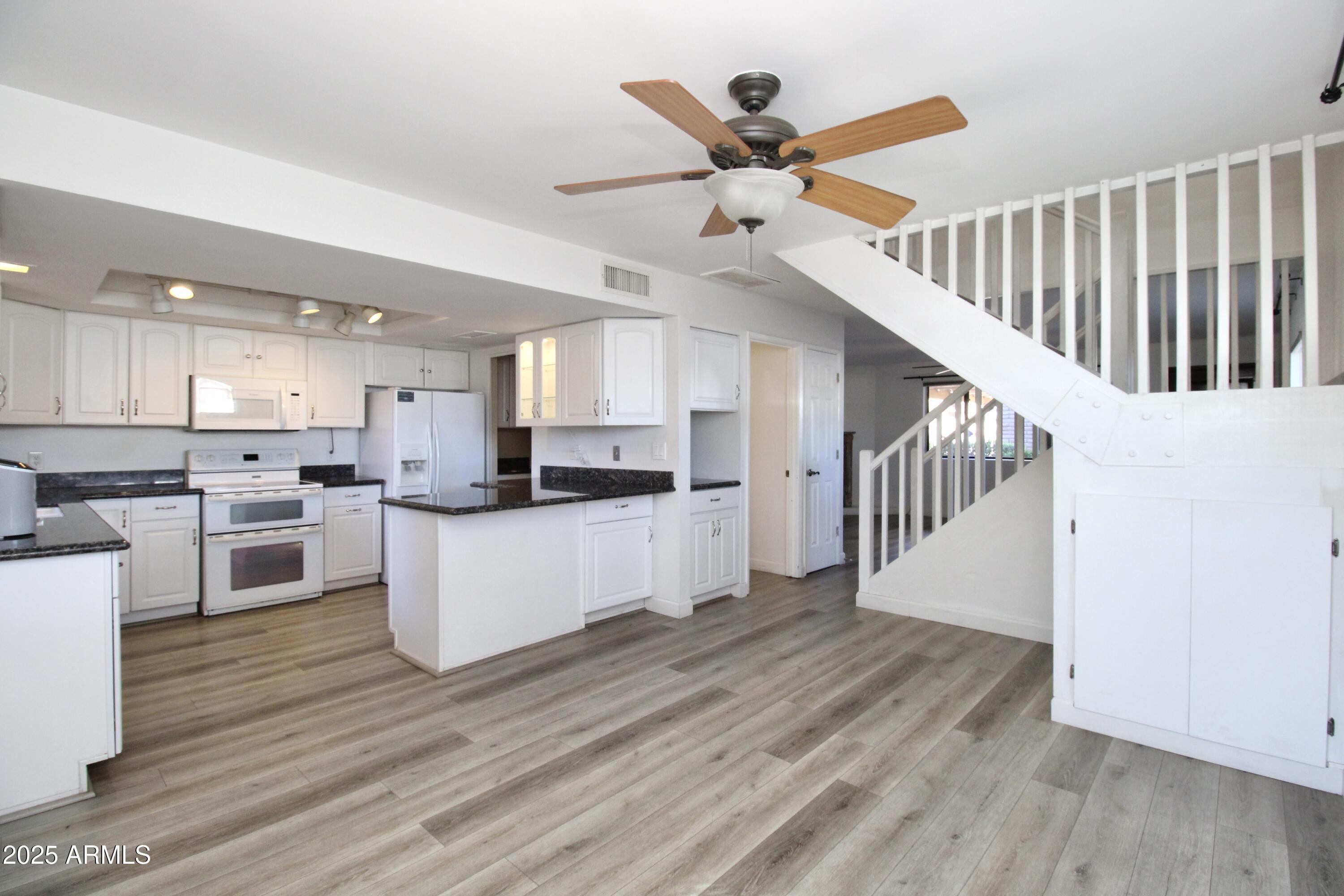 5330 North Central Avenue, Unit 19 Phoenix, AZ 85012 - Photo 6 of 33 a large kitchen with white cabinets stainless steel appliances and a chandelier