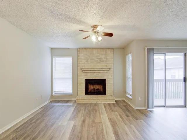 wooden floor fireplace and windows in an empty room