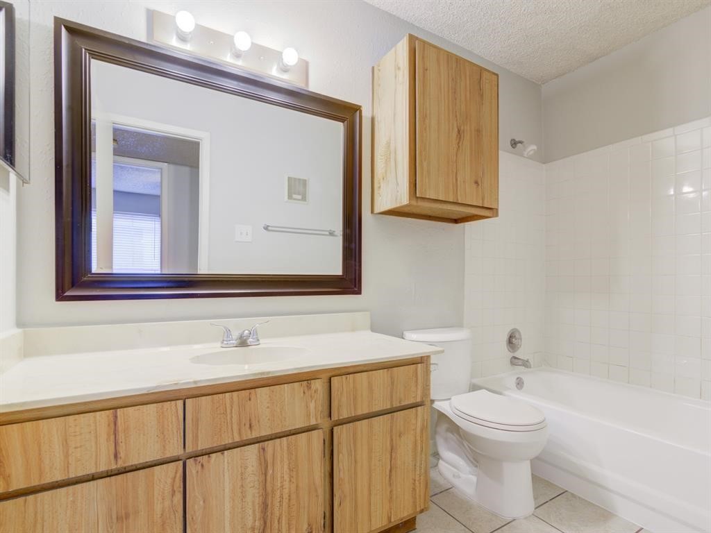 1900 Bay Area Boulevard, Unit T194 Houston, TX 77058 - Photo 6 of 21 a bathroom with a sink a toilet and mirror