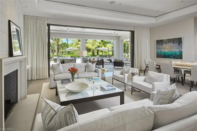 a dining hall with stainless steel appliances granite countertop a stove a refrigerator a sink with a dining table and chairs with wooden floor