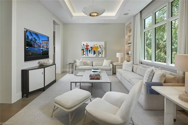 a living room with furniture a flat screen tv and a large window