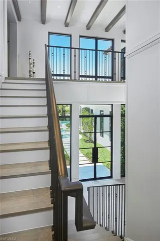 a view of a hallway with wooden floor and stairs