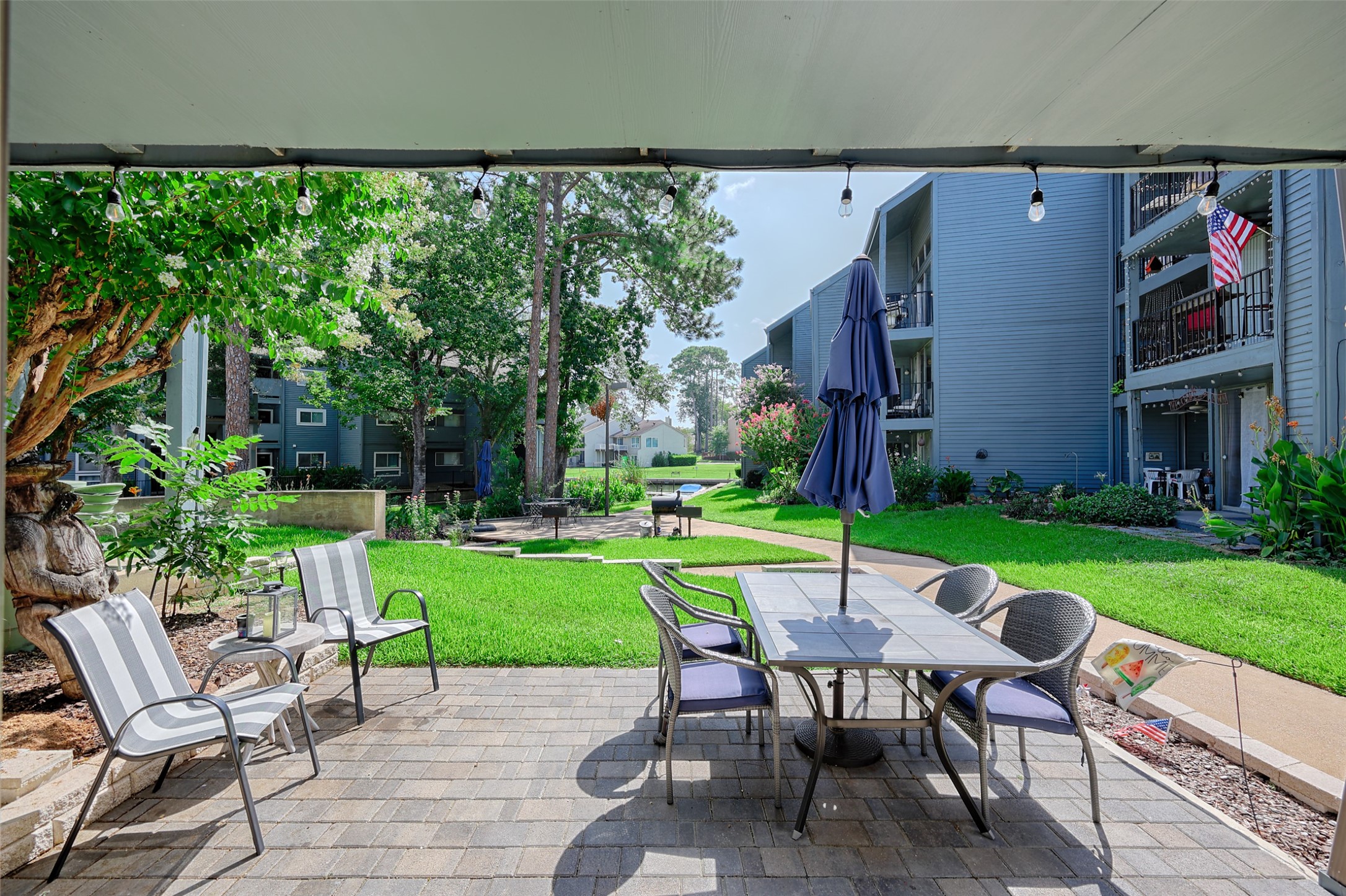12500 Melville Drive, Unit 123C Montgomery, TX 77356 - Photo 27 of 31 a view of a chairs and table in patio with a yard