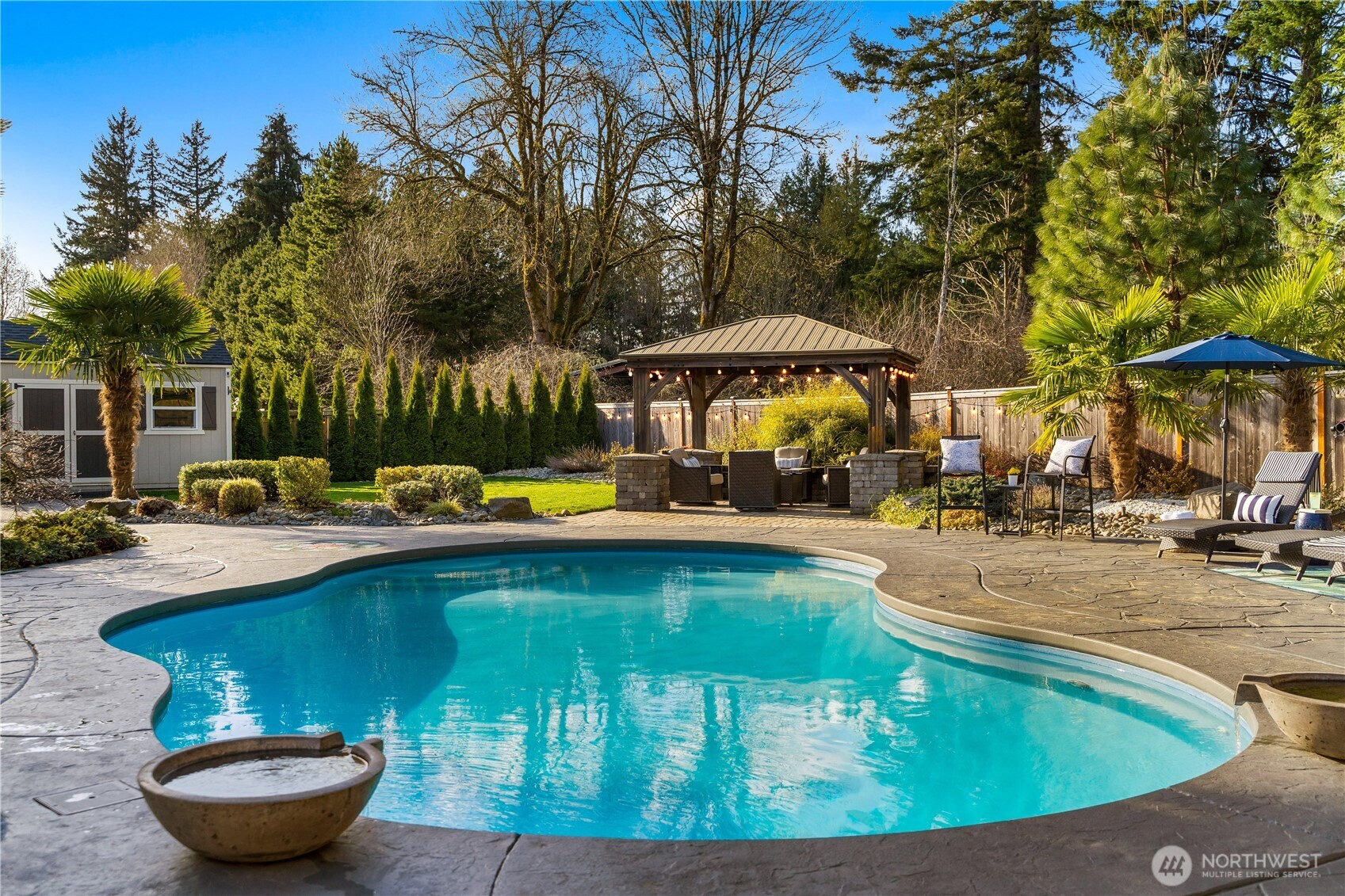 4244 90th Way Southeast Olympia, WA 98501 - Photo 35 of 40 a view of swimming pool with lawn chairs under an umbrella