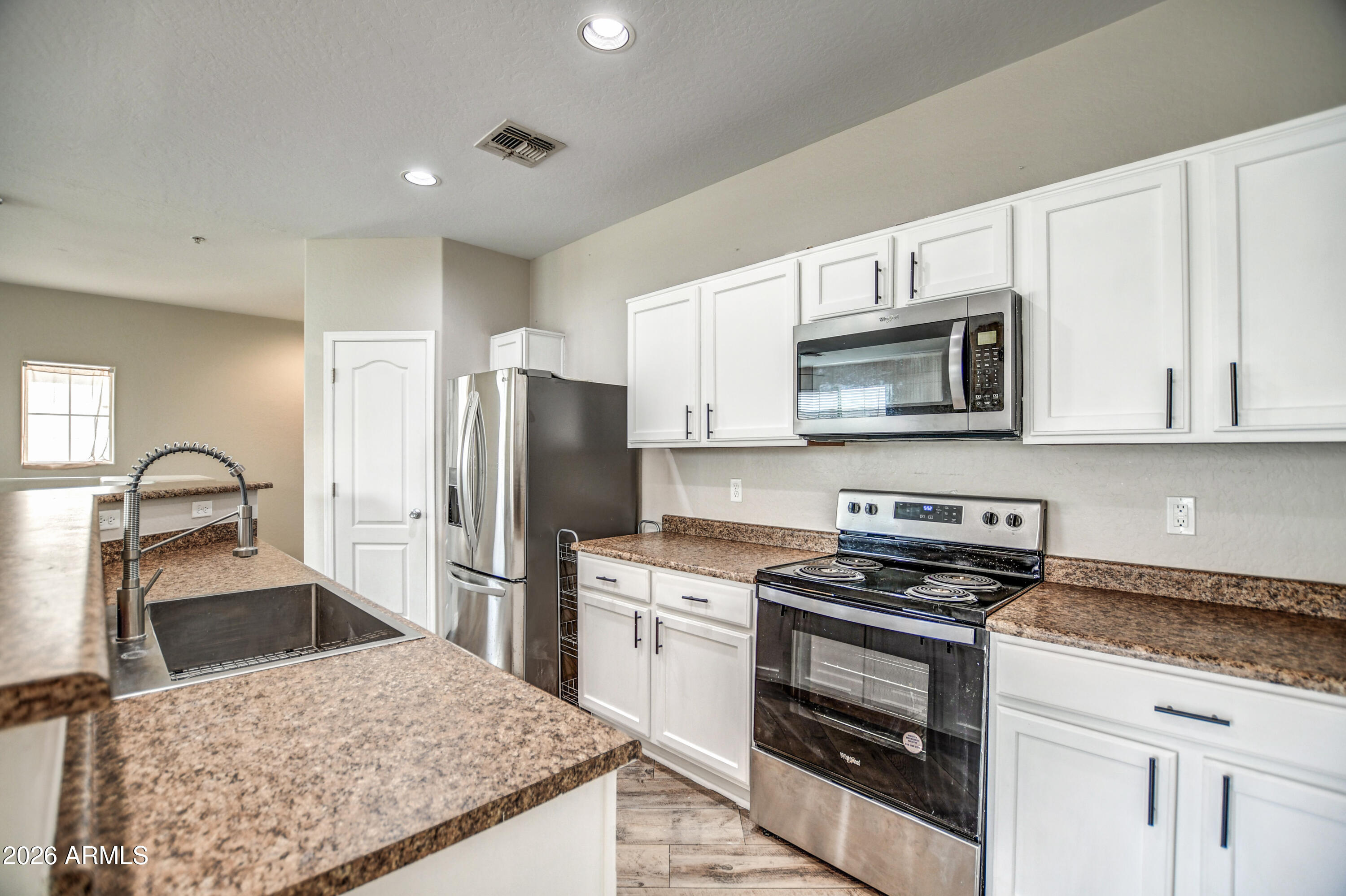 7515 South 30th Place Phoenix, AZ 85042 - Photo 3 of 23 a kitchen with granite countertop a refrigerator stove and microwave