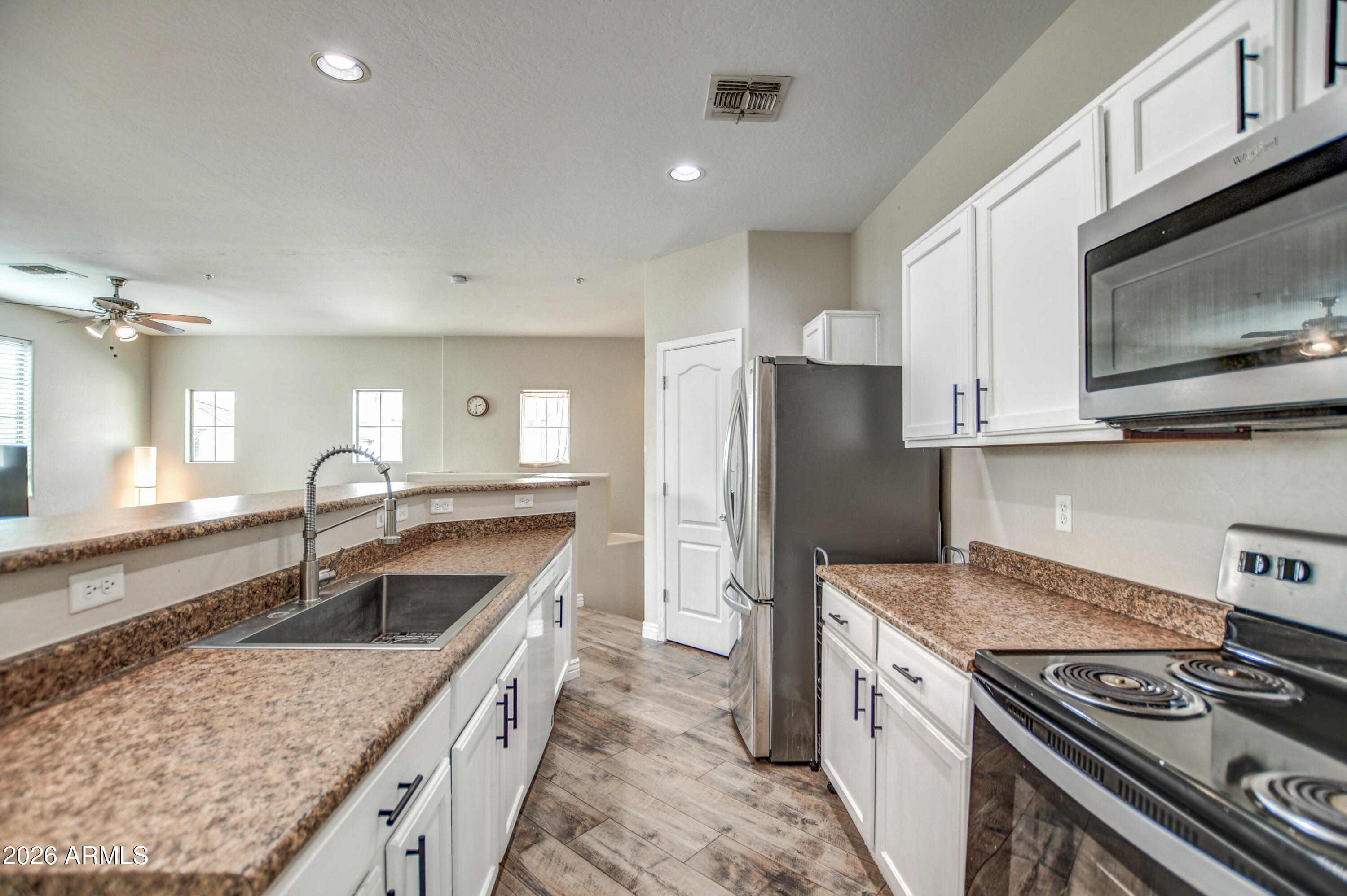 7515 South 30th Place Phoenix, AZ 85042 - Photo 5 of 23 a kitchen with stainless steel appliances granite countertop a sink stove and refrigerator