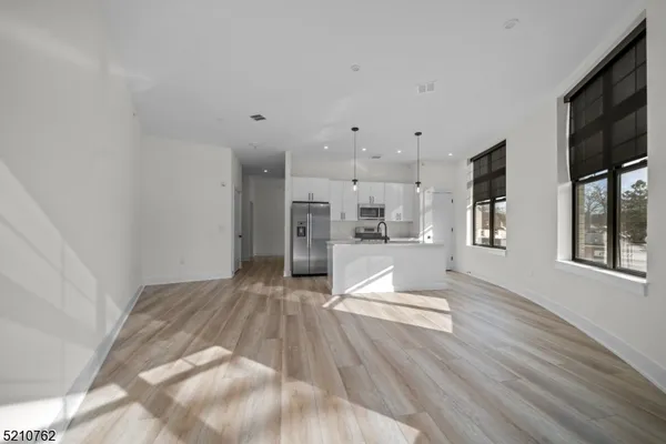 a view of kitchen with refrigerator stove and wooden floor