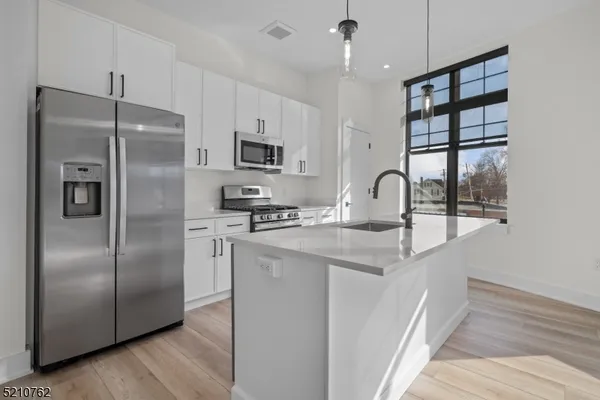 a kitchen with stainless steel appliances granite countertop a refrigerator and a sink