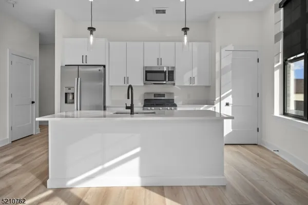 a kitchen with stainless steel appliances a refrigerator sink and microwave