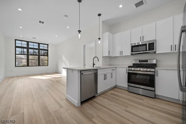 a kitchen with granite countertop a stove a sink and a refrigerator