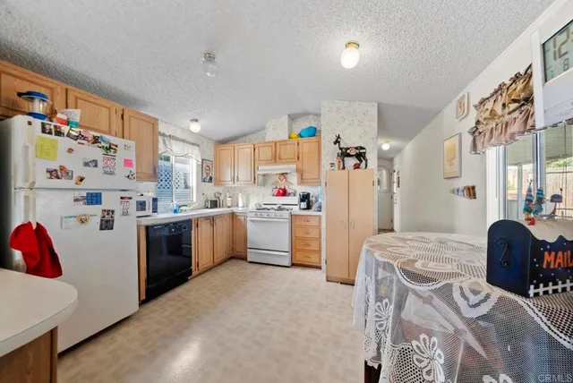 a kitchen with a refrigerator and white cabinets
