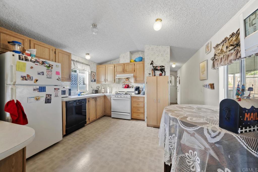 12044 Royal Road, Unit SPC 18 El Cajon, CA 92021 - Photo 4 of 24 a kitchen with a refrigerator and white cabinets