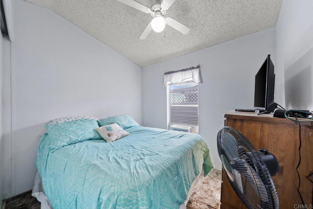 12044 Royal Road, Unit SPC 18 El Cajon, CA 92021 - Photo 8 of 24 a bedroom with a bed and a flat tv screen on the dresser