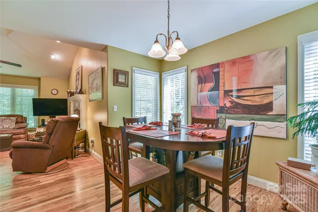 a dining room with furniture a chandelier and wooden floor