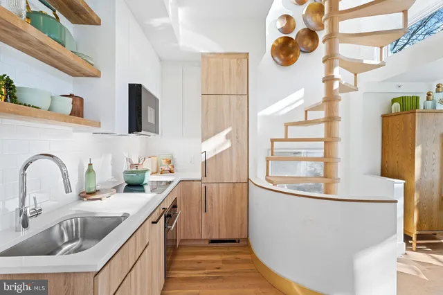 a kitchen with stainless steel appliances granite countertop a sink and a refrigerator
