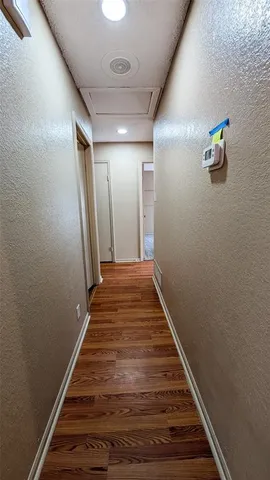 a view of a hallway with wooden floor