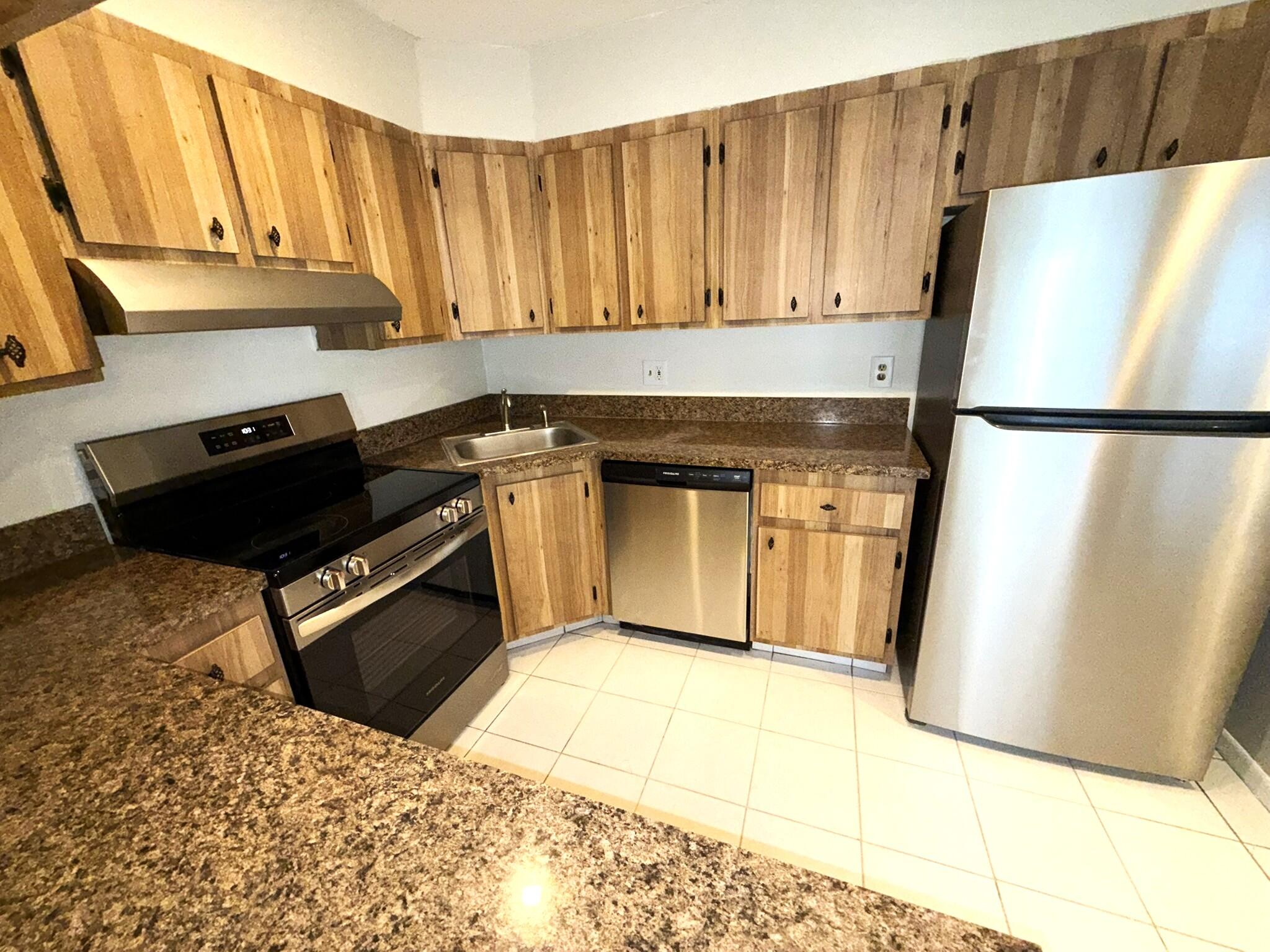 4987 Sable Pine Circle, Unit B2 West Palm Beach, FL 33417 - Photo 2 of 12 a kitchen with a refrigerator and a stove