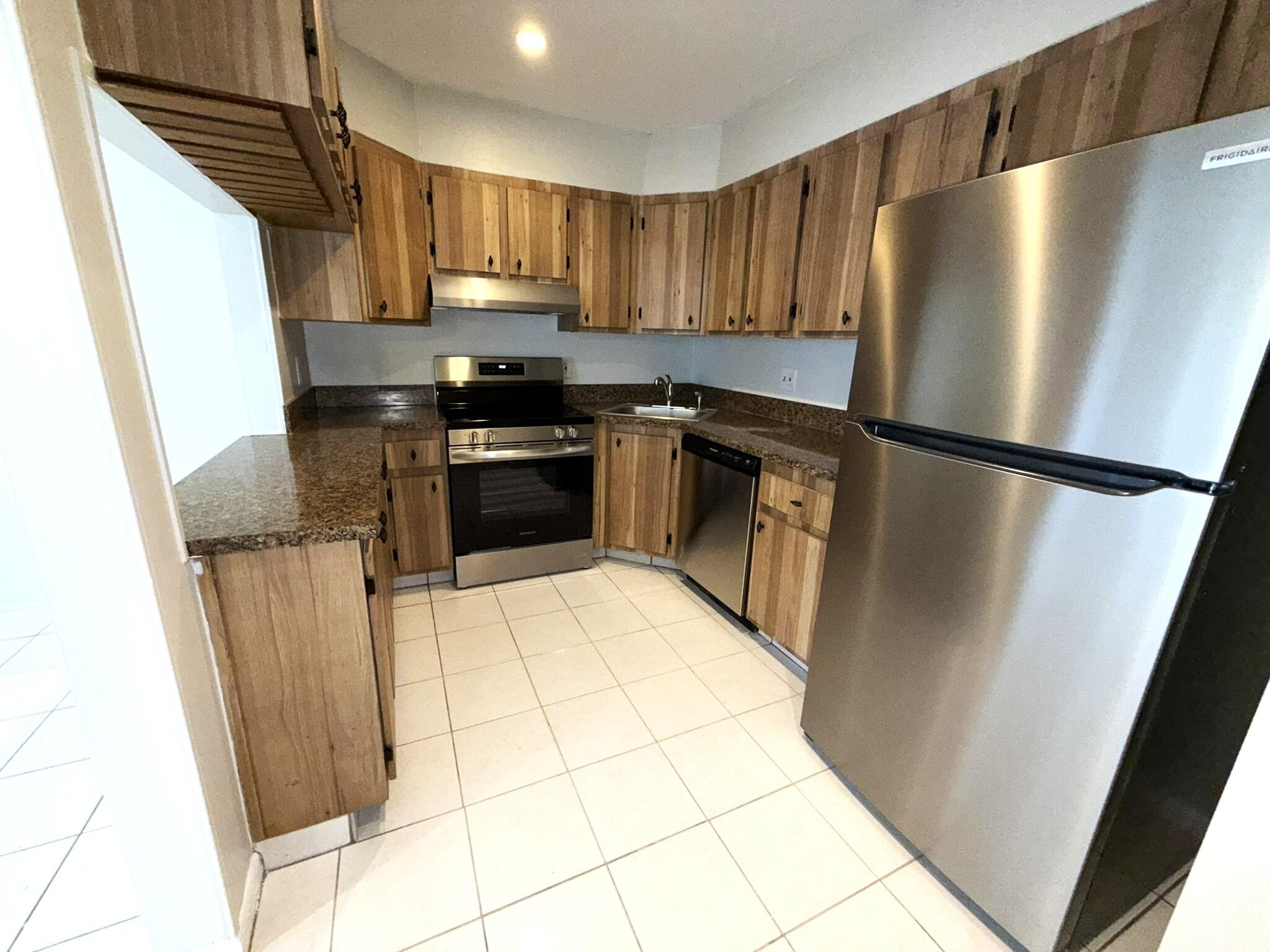 4987 Sable Pine Circle, Unit B2 West Palm Beach, FL 33417 - Photo 5 of 12 a kitchen with a refrigerator a stove a sink and a window