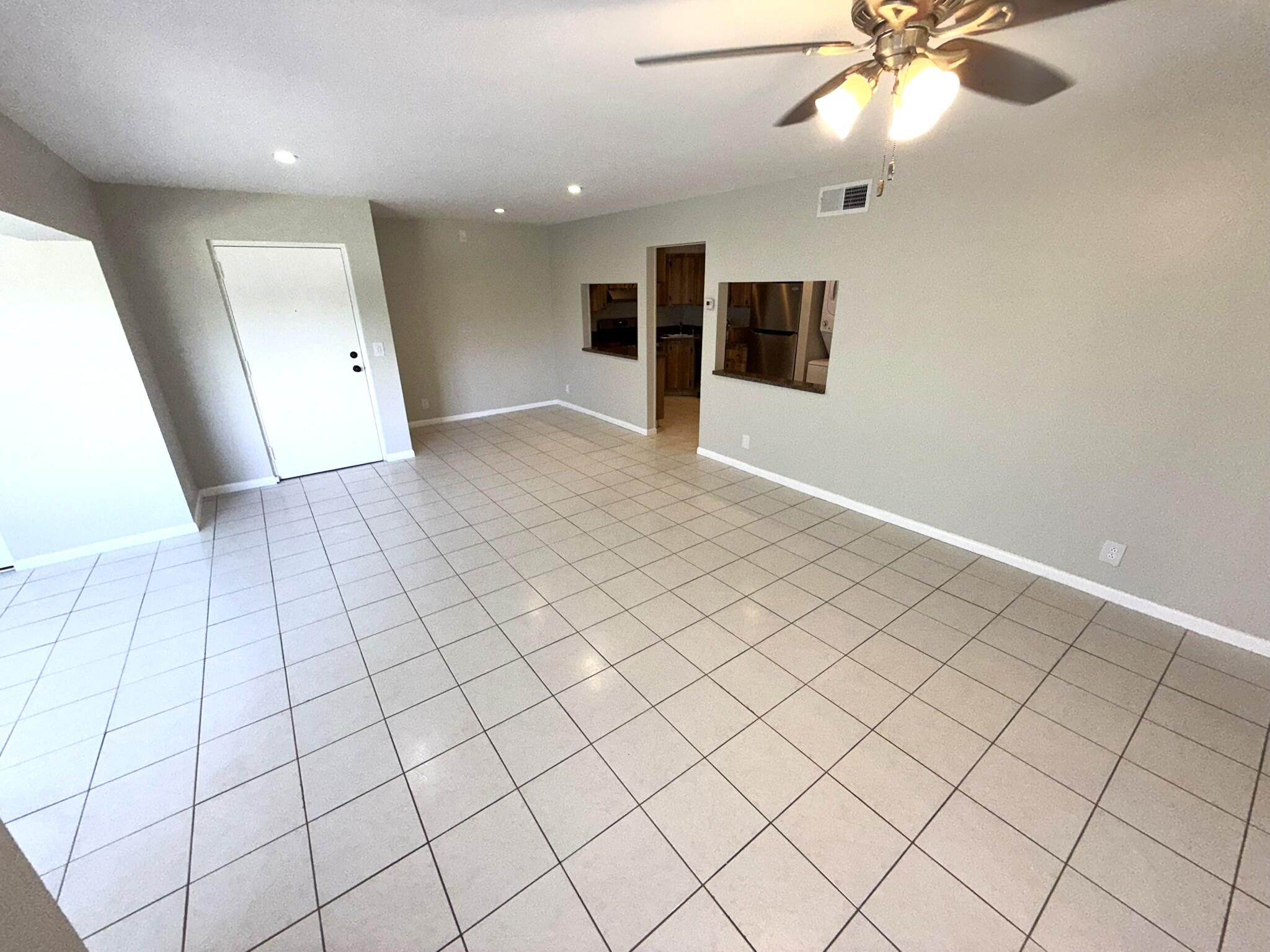 4987 Sable Pine Circle, Unit B2 West Palm Beach, FL 33417 - Photo 7 of 12 an empty room with windows and fan