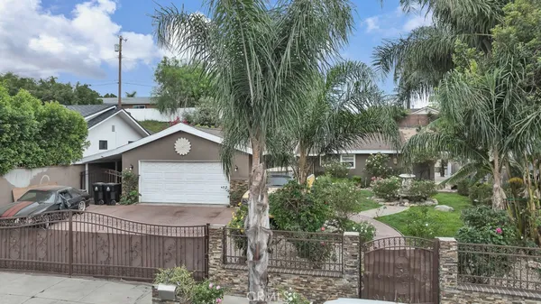 a front view of house with yard and trees around