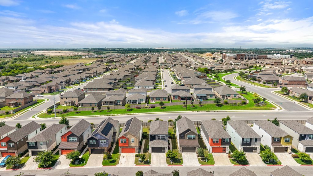 7403 Travertine Spring Drive, Unit 117 Austin, TX 78744 - Photo 35 of 37 An aerial panorama reveals a vast, well-planned residential community with uniform housing and verdant landscaping.
