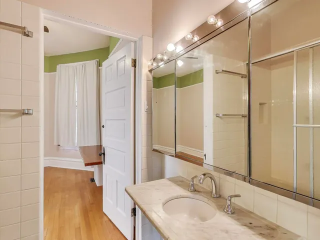 a bathroom with a granite countertop shower sink and mirror