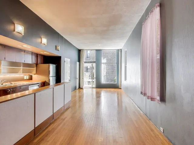 a large kitchen with a wooden floor and large windows
