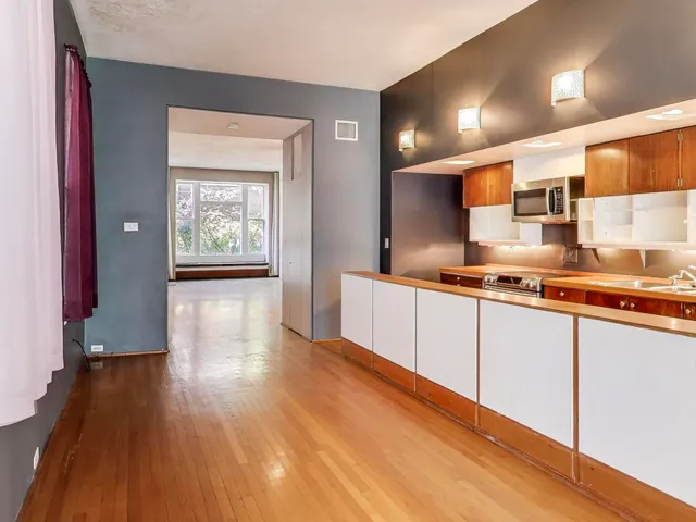 a open kitchen with stainless steel appliances granite countertop a sink and cabinets with wooden floor