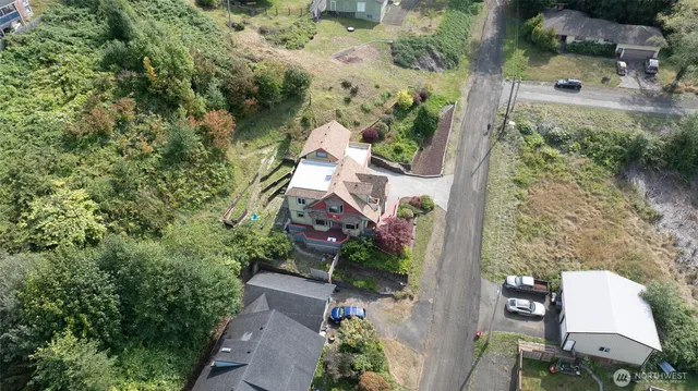 an aerial view of ocean and residential houses with outdoor space