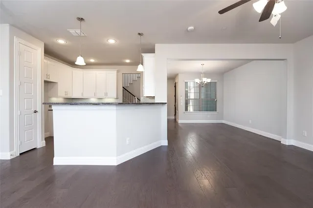 a view of a kitchen with cabinets and wooden floor