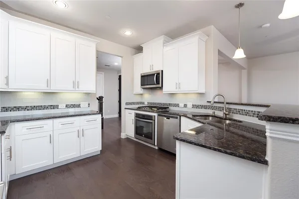 a kitchen with stainless steel appliances granite countertop a stove a sink and a granite counter tops