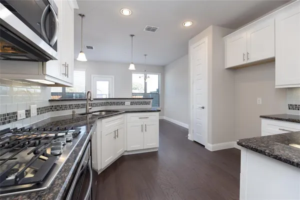 a kitchen with stainless steel appliances granite countertop a sink a stove and a refrigerator