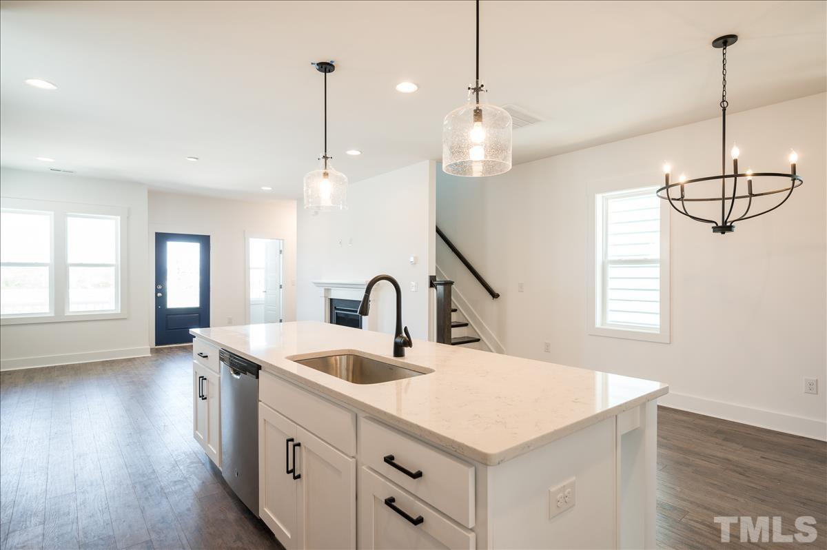 205 Daniel Ridge Road, Unit 1232 Wendell, NC 27591 - Photo 11 of 26 a kitchen with kitchen island white cabinets and white appliances