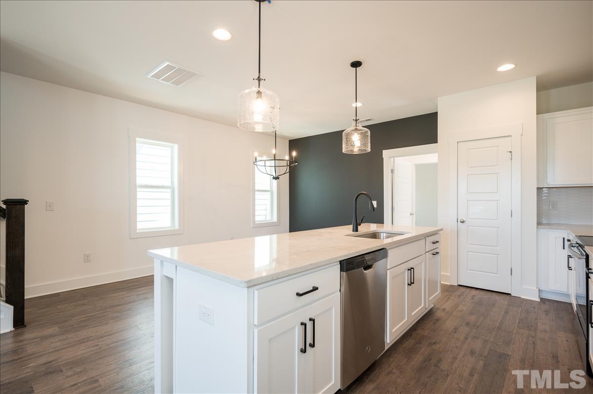 205 Daniel Ridge Road, Unit 1232 Wendell, NC 27591 - Photo 12 of 26 a large kitchen with kitchen island a stove a sink a center island and wooden floor
