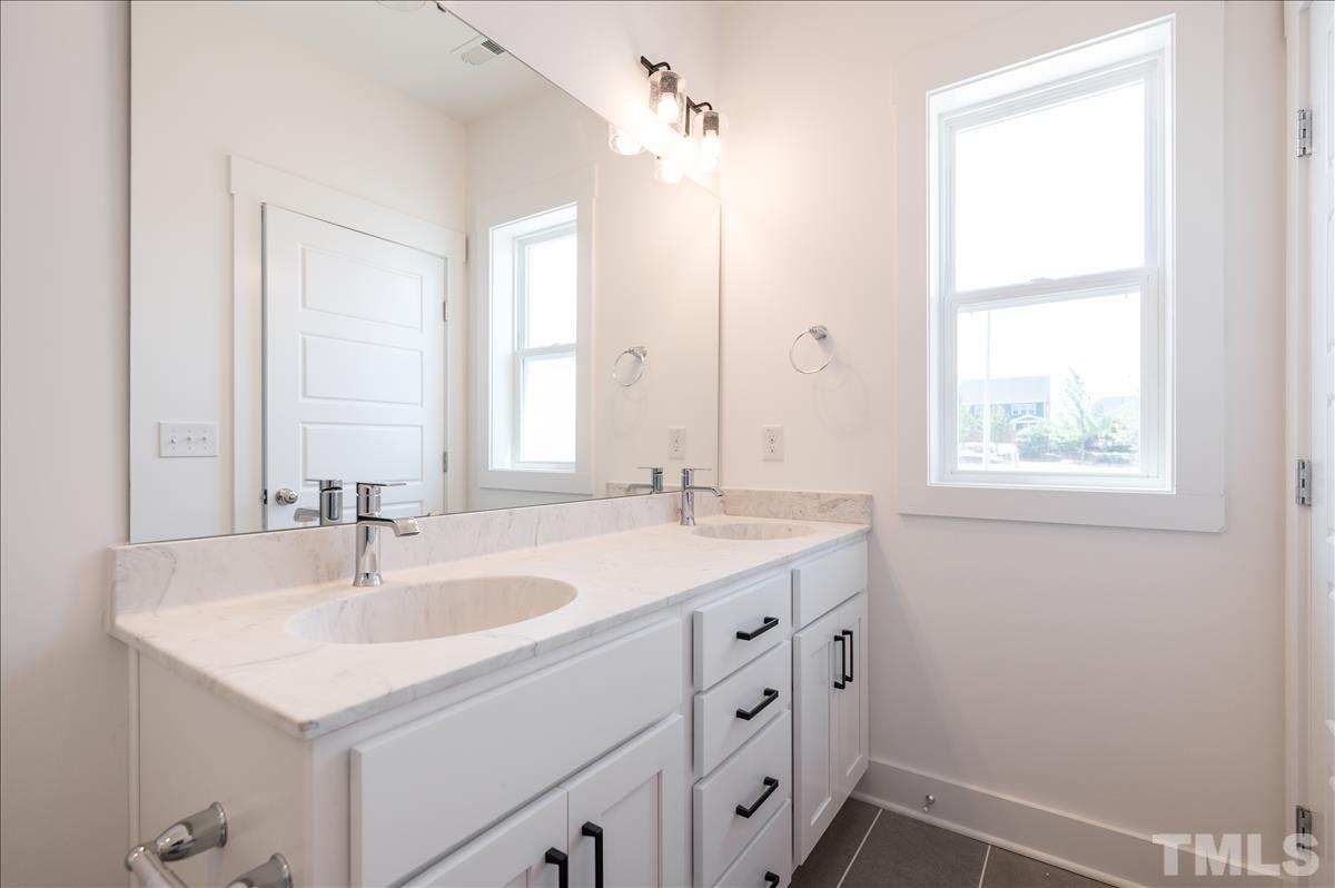 205 Daniel Ridge Road, Unit 1232 Wendell, NC 27591 - Photo 17 of 26 a bathroom with a sink and a mirror