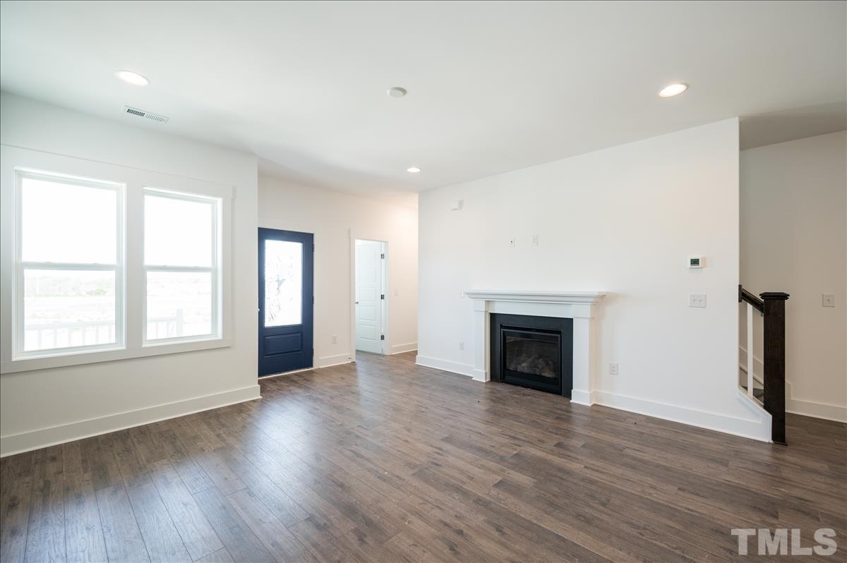 205 Daniel Ridge Road, Unit 1232 Wendell, NC 27591 - Photo 5 of 26 an empty room with wooden floor and fireplace