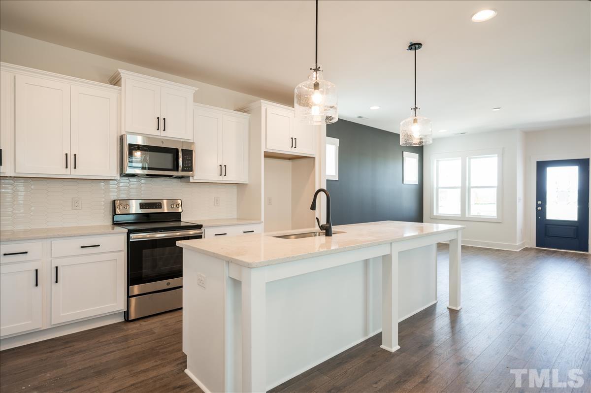 205 Daniel Ridge Road, Unit 1232 Wendell, NC 27591 - Photo 10 of 26 a kitchen with stainless steel appliances granite countertop a sink a stove a refrigerator and white cabinets