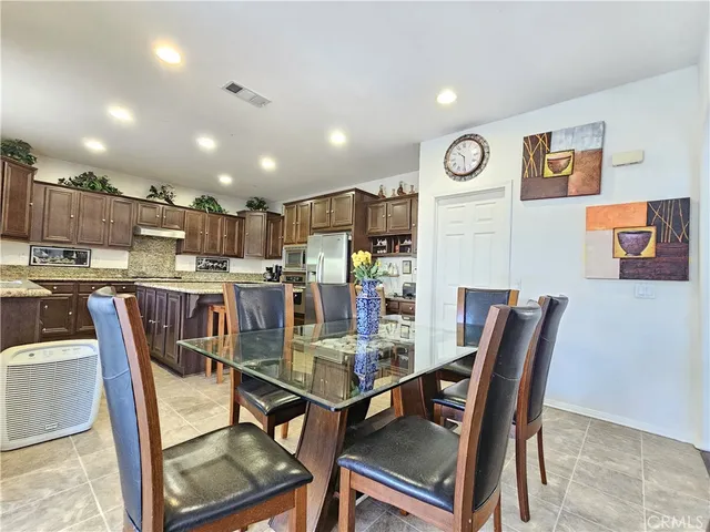a dining room with kitchen island furniture a kitchen view and a appliances