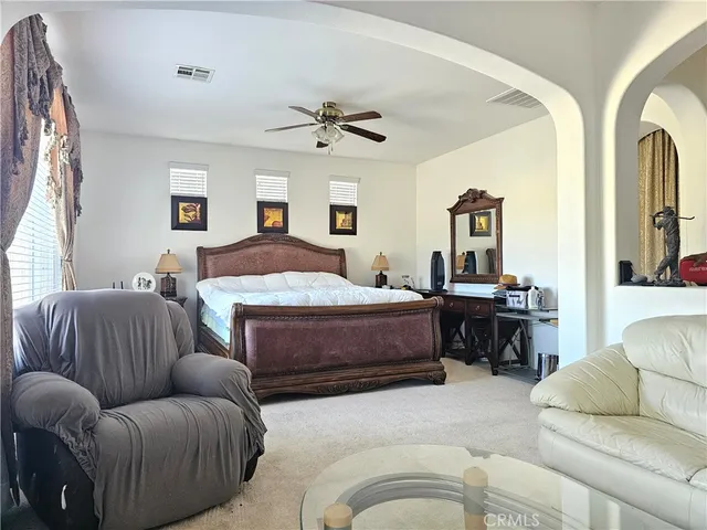 a bedroom with a large bed couch and a window