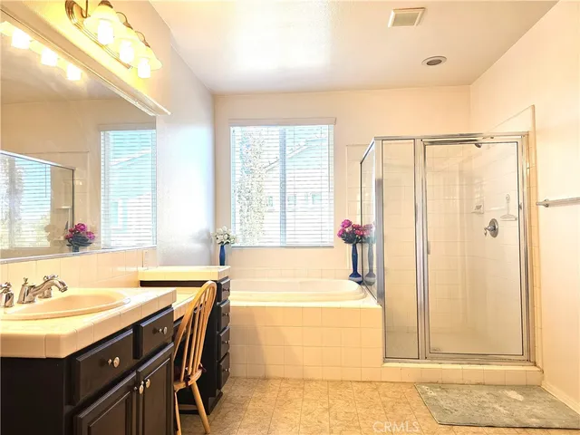 a spacious bathroom with a double vanity sink bathtub and next to a window