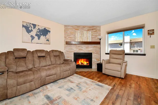 a living room with furniture a large window and a fireplace