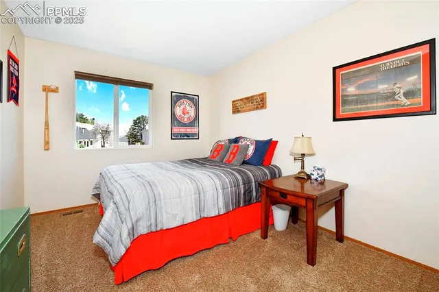 a bedroom with a bed and a painting on the wall