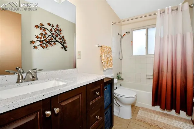 a bathroom with a granite countertop sink mirror vanity and toilet