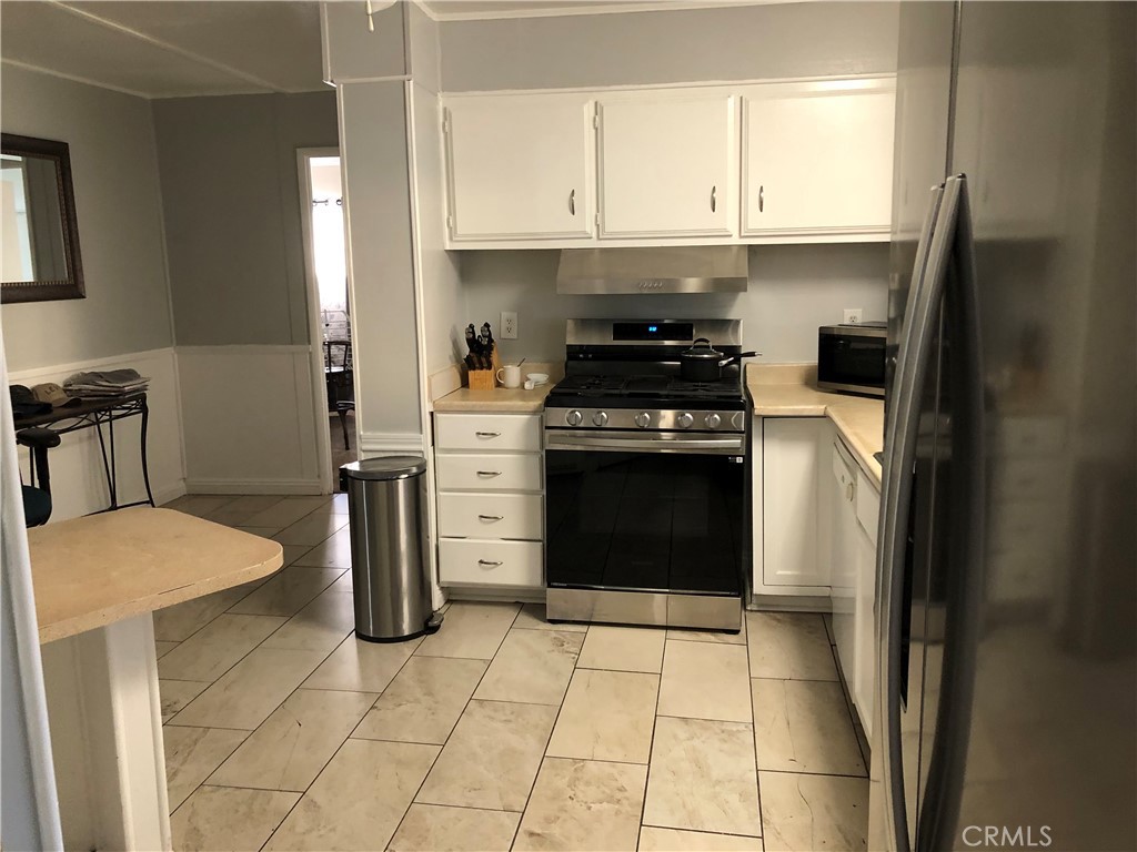 4901 Green River Road, Unit 113 Corona, CA 92878 - Photo 4 of 22 a kitchen with a stove a refrigerator and cabinets