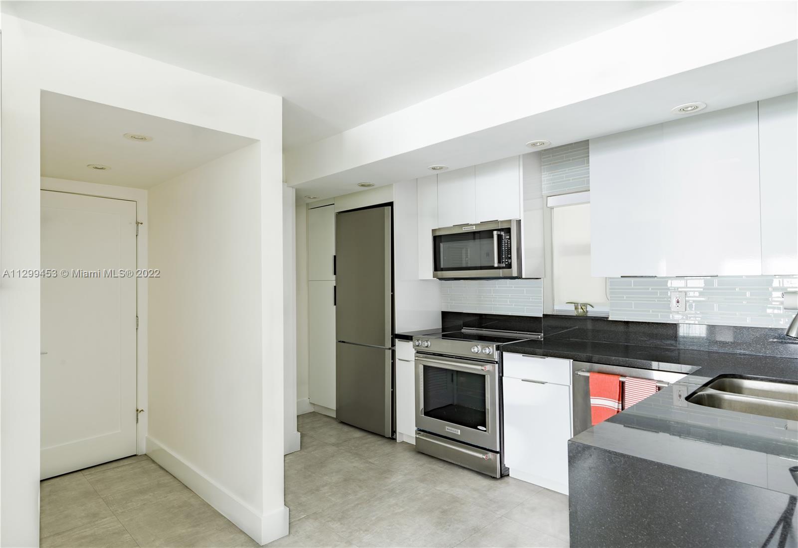 1674 Bay Road, Unit 504 Miami Beach, FL 33139 - Photo 4 of 10 a kitchen with stainless steel appliances granite countertop a stove and a microwave