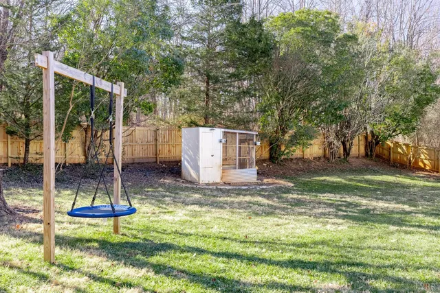 a view of a house with a small yard and wooden floor and fence