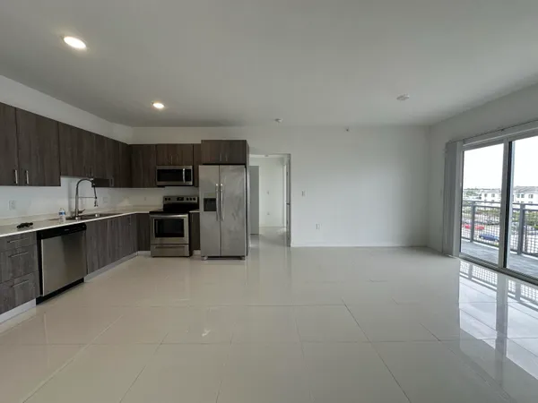 a kitchen with granite countertop a refrigerator and a stove top oven